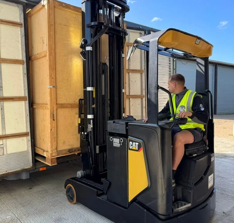 Wolves Storage Sussex operator loading a sealed wooden storage container with a CAT forklift at our secure West Sussex facility