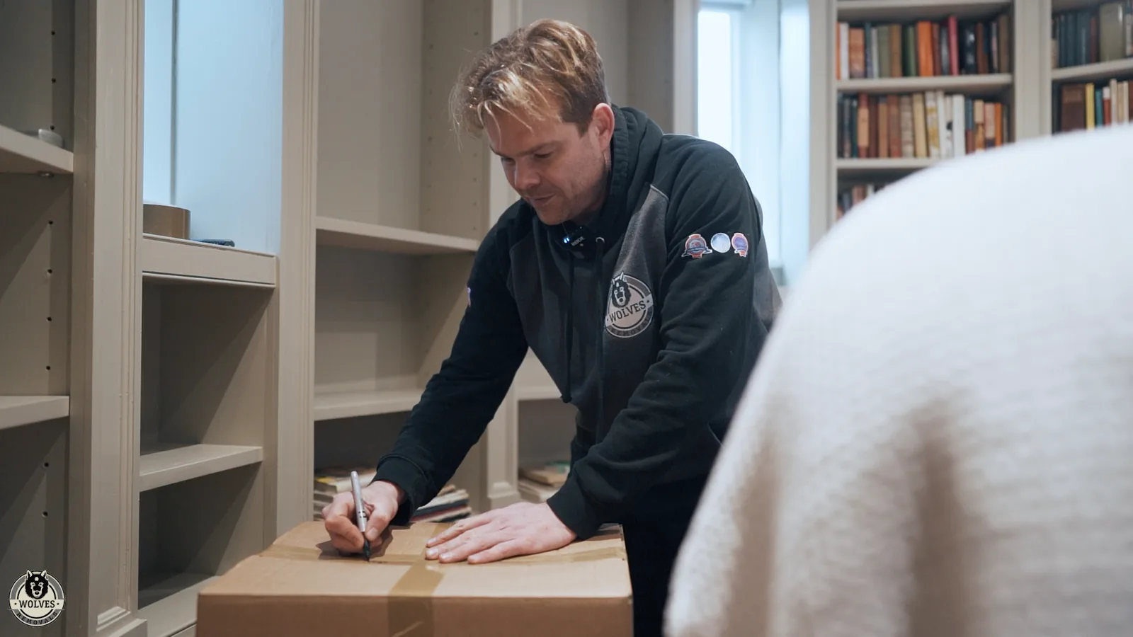 A Wolves team member labelling a carefully packed box of books — Wolves Storage Sussex serving Ashington