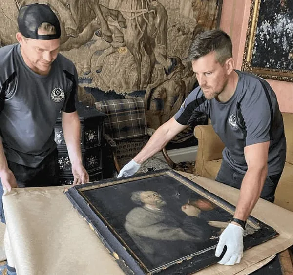 Wolves Storage Sussex team handling an antique painting with white gloves