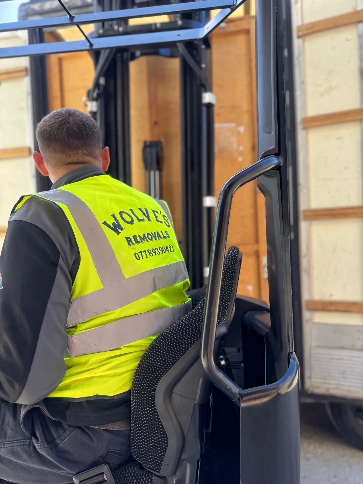 Operator moving sealed storage containers by forklift