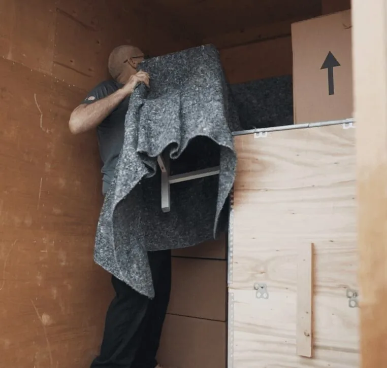 A Wolves Storage Sussex mover wrapping a chair in a protective blanket inside a storage container &mdash; Wolves Storage Sussex serving Storrington