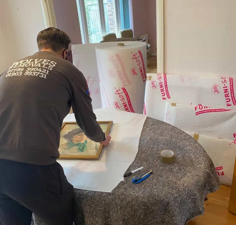 A Wolves Storage Sussex packer wrapping a framed picture in Furni-soft padding