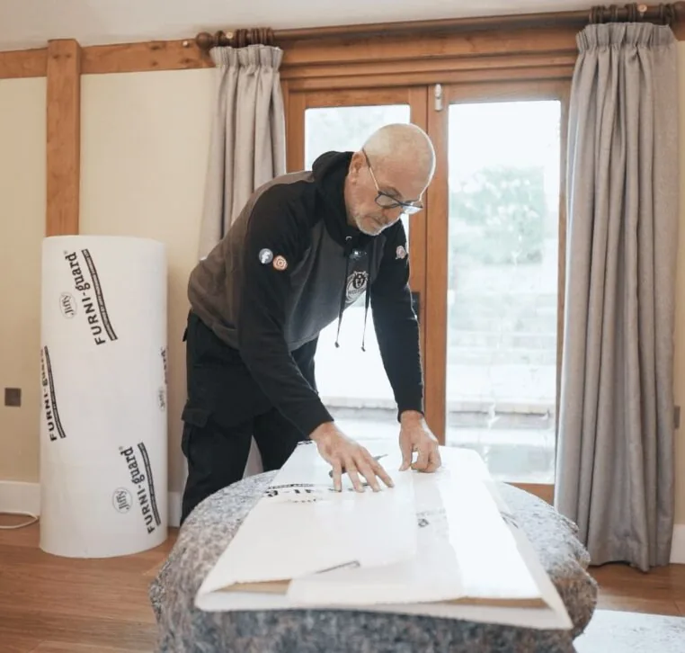 A Wolves Storage Sussex packer protecting a marble-topped table with Furni-guard &mdash; Wolves Storage Sussex serving Arundel